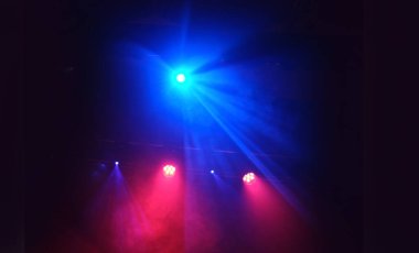 Sahne ışıkları kırmızı ve mavi renkte bir müzik gösterisinde.