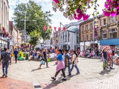 Güneşli bir günde Broad Street 'te alışveriş yapan kalabalık Berkshire UK okuyor..