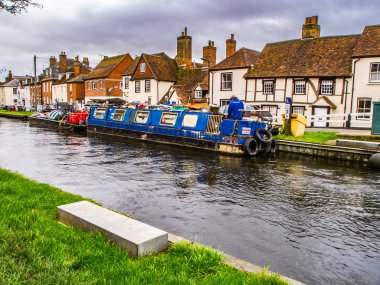 Kennet ve Avon Kanalı ve Towpath. Kırmızı teneke kutuları ve arkasında evleri olan yakıt tankları dar..