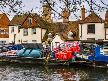Kennet ve Avon Kanalı ve Towpath. Kırmızı teneke kutuları ve arkasında evleri olan yakıt tankları dar..