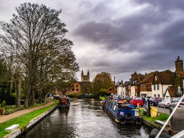 Kennet ve Avon Kanalı ve Towpath. Kırmızı teneke kutuları ve arkasında evleri olan yakıt tankları dar..