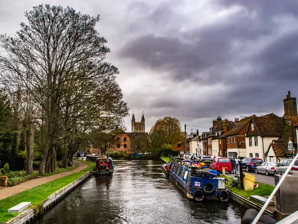 Kennet ve Avon Kanalı ve Towpath. Kırmızı teneke kutuları ve arkasında evleri olan yakıt tankları dar..