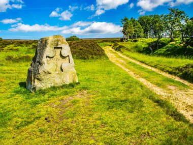 Lastingham marker stone on North York Moors, North Yorkshire. Track leading across the moors clipart
