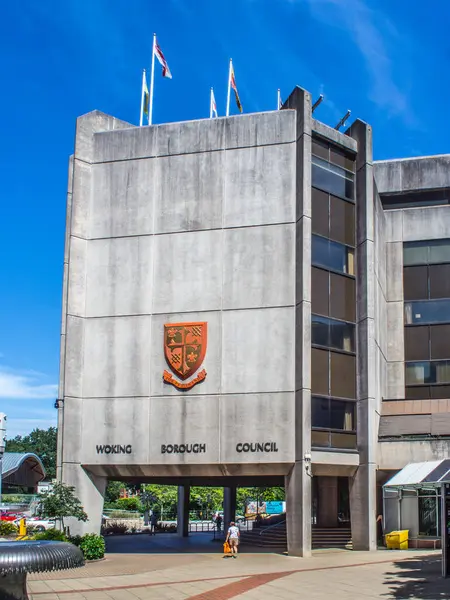 stock image Woking town centre. June 29 2024. Woking council offices external view with a pedestrian. Blue sky.