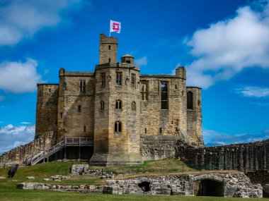 Warkworth Kalesi, Northumberland, İngiltere. Kalan taş duvarlar ve bayraklar kalsın.