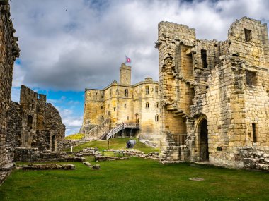 Warkworth Kalesi, Northumberland, İngiltere. Kalan taş duvarlar ve bayrak sende kalsın..