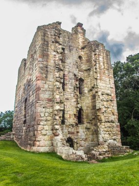 Etal, Northumberland 'da bir yaz gününde yeşil çimenli ve bulutlu gökyüzü olan bir şato.