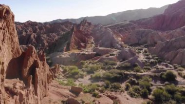 The guy looks at the landscape in front of him. A tourist stands on a hill in a red canyon. Red Canyon Fiery Tale. Kyrgyzstan