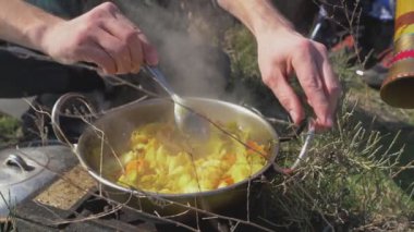 Kamp koşullarında yemek pişirmek. Sağlıklı beslenme. Karıştırıcı bir yemek kaşığının yakın çekimi..