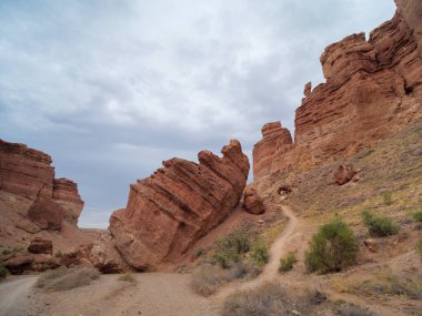 Charyn Canyon Ulusal Parkı. Kaleler Vadisi 'nin dibindeki yol. Kızıl kaya oluşumları milyonlarca yıllık erozyonun bir sonucu olarak oluştu. ABD Büyük Kanyonu 'nun küçük bir kopyası..