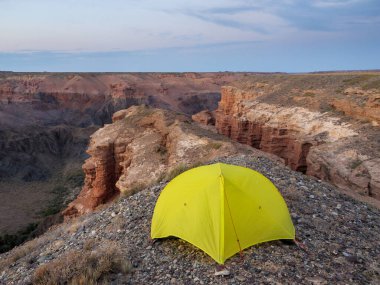 Charyn Kanyonu manzaralı bir çadır. Kızıl kaya oluşumları milyonlarca yıllık erozyondan oluşmuştur. ABD Büyük Kanyonu 'nun küçük bir kopyası.