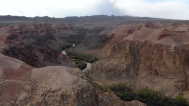 Charyn Canyon Ulusal Parkı. Kaleler Vadisi 'nin dibindeki yol. Kızıl kaya oluşumları milyonlarca yıllık erozyonun bir sonucu olarak oluştu. ABD Büyük Kanyonu 'nun küçük bir kopyası..