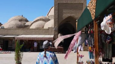 Buğhara, UZBEKISTAN - 23 Eylül 2023: eski şehrin caddesinde. Geleneksel kumaş ve hediyelik eşya tezgahları