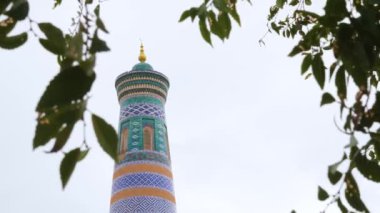 Maviyle kaplı antik bir minare ve süslemeli turkuaz fayanslar. Khiva, Özbekistan 'da İslam Khoja Minaresi