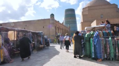 Antik kale Ichan-Kala 'nın alışveriş caddeleri. Özbekistan 'ın antik Khiva kenti. Turistler yürürler ve hediyelik eşya alırlar. Kalta Minar Görünümü