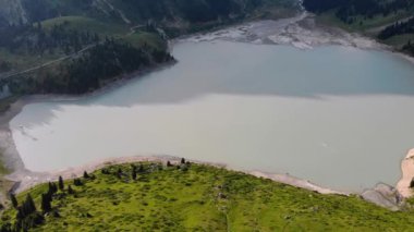 Büyük Almaty Gölü ve yazın baraj manzarası. Göldeki su, buzulların aktif erimesi nedeniyle bulutludur.