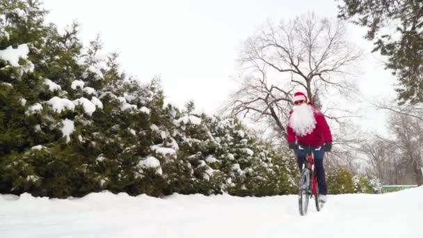 Święty Mikołaj Jeździ Rowerze Zimą Facet Brodą Kapeluszem Świętego Mikołaja — Wideo stockowe