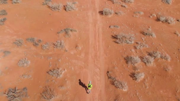 アスリートは砂漠を走っている クロスカントリーランニング 地球は赤かった 空中ビデオ撮影 上からの眺め — ストック動画