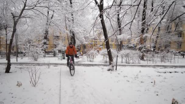 Хлопець Помаранчевій Куртці Їде Велосипеді Через Зимове Місто Серед Снігових — стокове відео