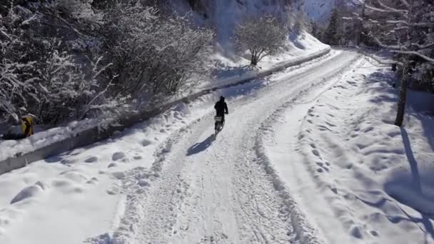 Zimą Człowiek Jeździ Rowerze Elektrycznym Górach Rowerzysta Śnieżnej Drodze Wśród — Wideo stockowe