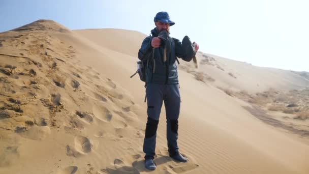 Турист Пустыне Высыпает Песок Ботинок Бородатый Путешественник Шляпе Жесткая Пустынная — стоковое видео