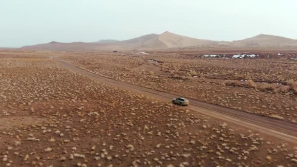 砂漠地帯で速く運転する車 寒い季節 雪の残り 粗い植生が付いている乾燥した区域 アルティン エルメル国立公園 — ストック動画