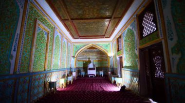 Khan 'ın sarayının iç dekorasyonu. Duvarlar renkli geleneksel süsler, taht ve halılarla süslenmiş. Antik Ichan-Kala, Khiva, Özbekistan