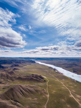 Baharın başında güneşli bir günde Tamgaly-Tas yolunun en üst manzarası. Ili Nehri kayalar arasında pitoresk bir manzara boyunca akar. Kazakistan