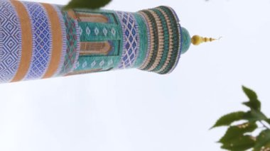 Mavi ve turkuaz karolarla kaplı antik bir minarenin dikey video görüntüleri. Khiva, Özbekistan 'da İslam Khoja Minaresi