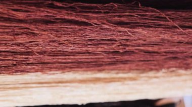 İpliğin dikey video görüntüleri, halıları geleneksel manuel olarak yapmak için iplikler. Çok renkli iplikler, doğu pazarında satılır.