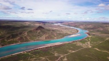 Bir bahar öğleden sonrası nehir vadisi manzarası. Bir İHA 'dan ateş etmek. Gök mavisi suyu olan nehir kayalık tepelerin arasından esiyor. Ili Nehri, Kazakistan