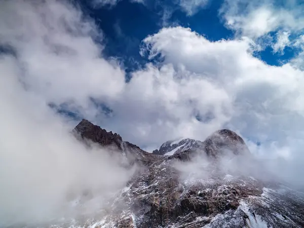 stock image Impregnable cliffs peek out of the clouds. Stony cliffs high in the mountains. Talgar Pass