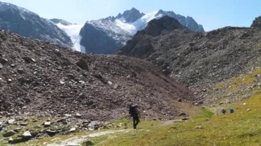 Dağlarda yürüyen sakallı adam. Yazın dağlarda tek başına yürüyüş. Bir adam dağlardaki kayalık bir tepenin tepesinde yürüyor. 2x ağır çekim