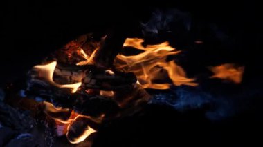 Yanan ateşin gece alevlerinin dikey video görüntüleri. Ağır çekim. Alevlerin dilleri güzelce yükselir