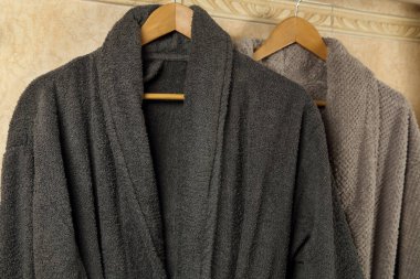 Banyoda asılı gri bornozlar.