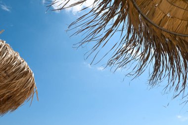 Mavi gökyüzü olan bir sahil şemsiyesi altında, yaz konsepti.