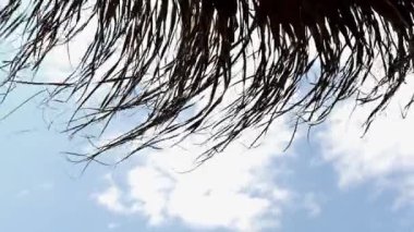 Parlak mavi gökyüzü olan saman plaj şemsiyesi