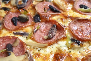 mozzarella, pepperoni, mantar ve zeytinli özel pizza.