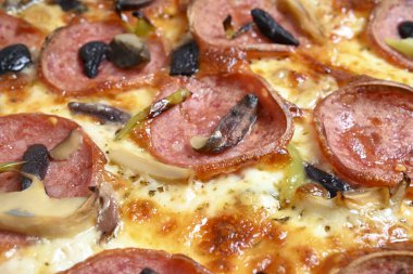 mozzarella, pepperoni, mantar ve zeytinli özel pizza.