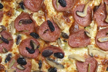 mozzarella, pepperoni, mantar ve zeytinli özel pizza.