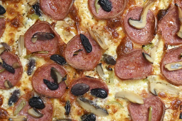 mozzarella, pepperoni, mantar ve zeytinli özel pizza.