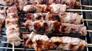 Souvlaki 'li ızgara ızgara ve onları çeviren biri.