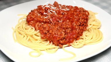 Pişmiş spagetti bolonezine peynir ekliyorum.