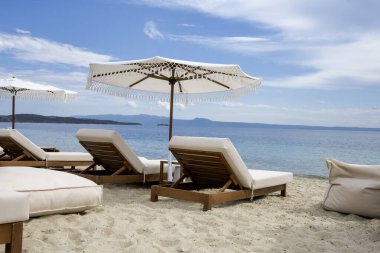 Şatafatlı güneşlikler ve şemsiyeler güzel bir sahilde.