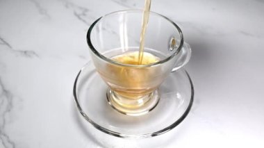 Şeffaf bardağa sıcak çay dolduruyorum.