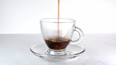 Şeffaf bardağa sıcak kahve dolduruyorum.
