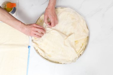 Mutfakta ıspanaklı turta hazırlayan kadın.