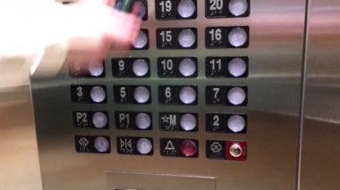 Asansörde 10. kattaki düğmeye basan bir kadının hareketi.