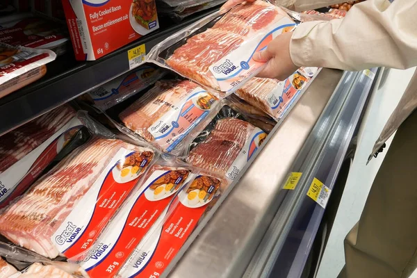 在沃尔玛商店里买高档咸肉的女人 免版税图库照片
