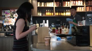 Bir kadının kahvesini bir Starbucks mağazasında 4K çözünürlüklü bir şekilde içmesi.